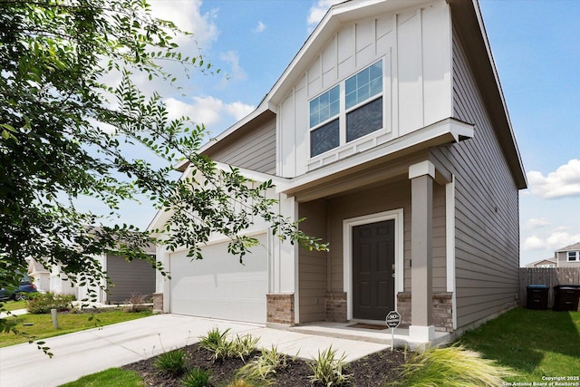 view of front of property featuring board and batten siding, driveway, a front yard, a garage, and fence