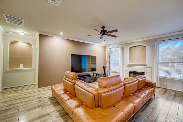 living room featuring a ceiling fan, visible vents, plenty of natural light, and light wood finished floors