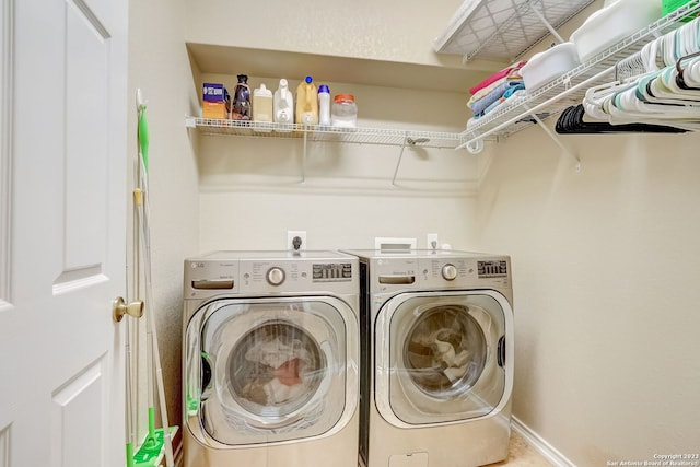 laundry area with baseboards, laundry area, and washer and dryer