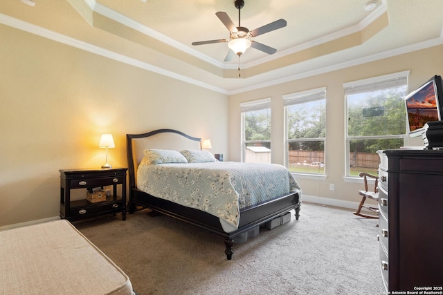 bedroom featuring crown molding, a raised ceiling, baseboards, and carpet flooring