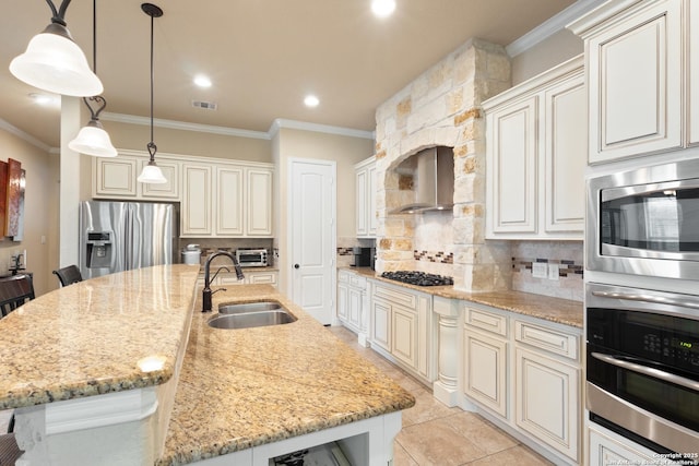 kitchen featuring visible vents, crown molding, a sink, stainless steel appliances, and wall chimney exhaust hood