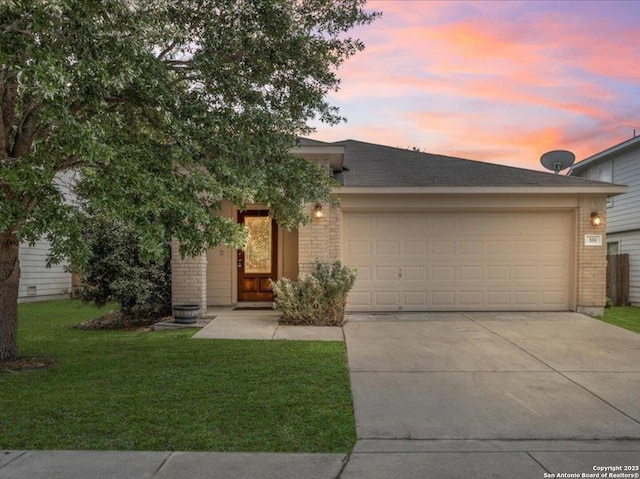 view of front facade with an attached garage, driveway, a front lawn, and brick siding