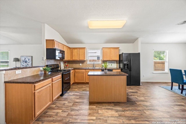 kitchen with a kitchen island, backsplash, dark wood-style flooring, vaulted ceiling, and black appliances