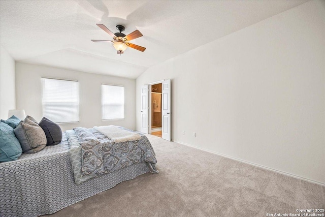 bedroom with a ceiling fan, vaulted ceiling, baseboards, ensuite bathroom, and carpet