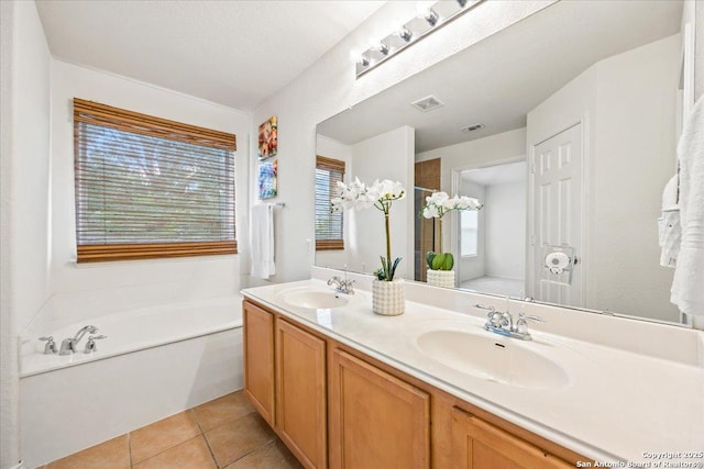 full bath with a sink, tile patterned floors, a bath, and visible vents