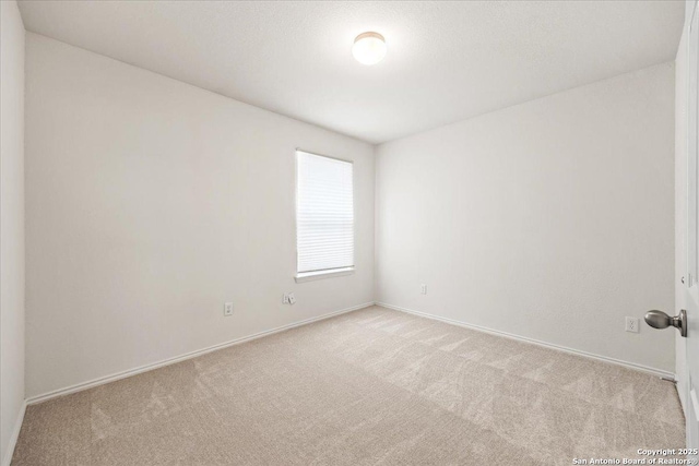 carpeted empty room featuring baseboards