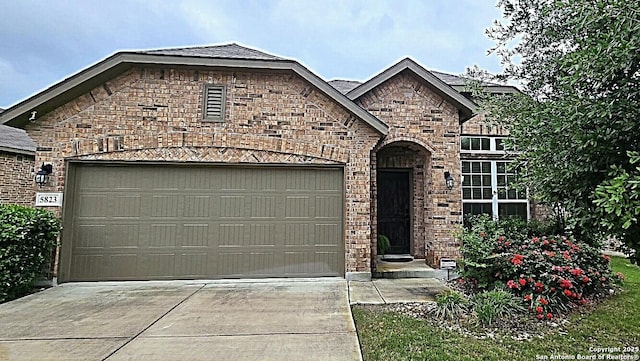 french country style house with brick siding, driveway, and a garage