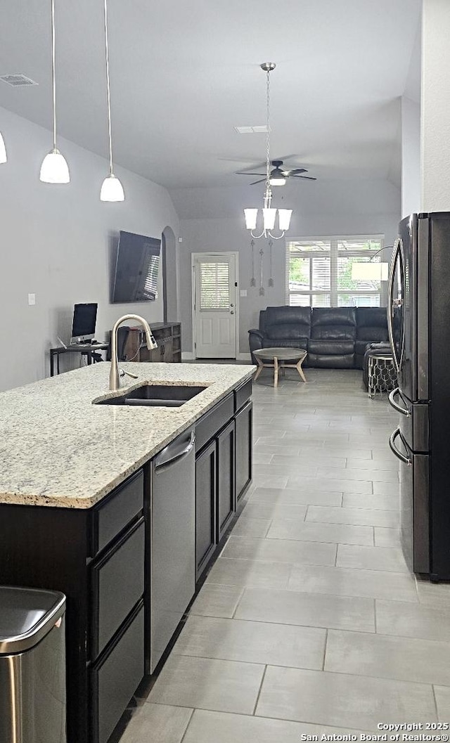 kitchen with a healthy amount of sunlight, dishwasher, a sink, freestanding refrigerator, and open floor plan