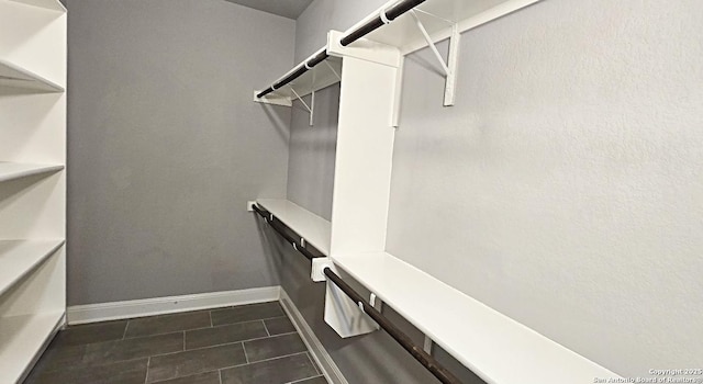 spacious closet featuring dark tile patterned floors