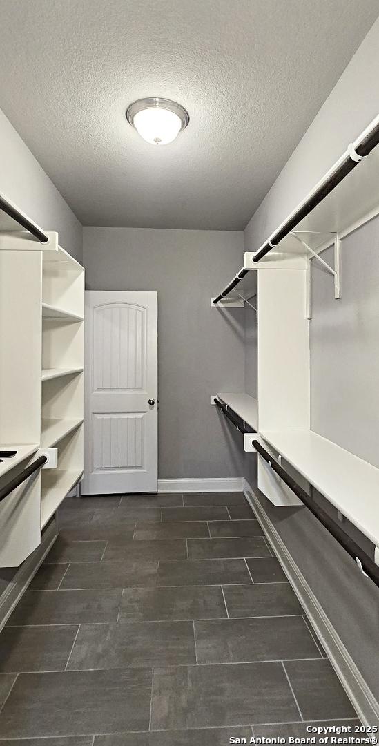 walk in closet with wood tiled floor