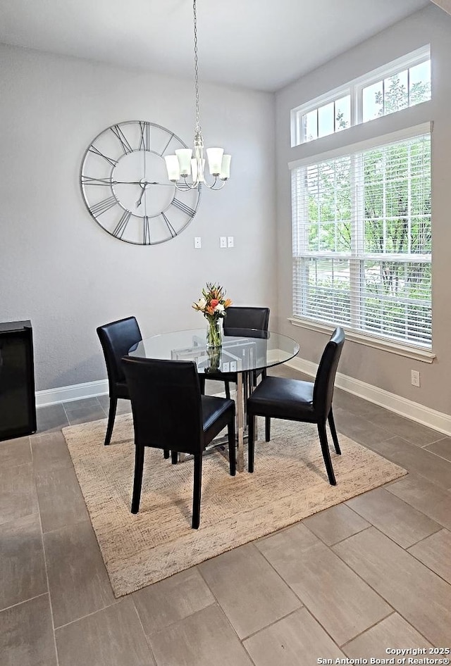 dining area featuring baseboards and a notable chandelier