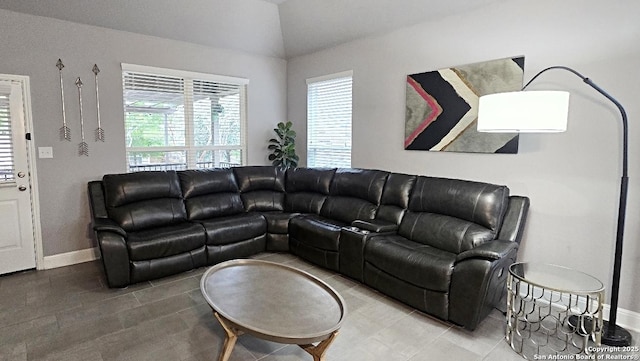 tiled living room featuring baseboards and vaulted ceiling