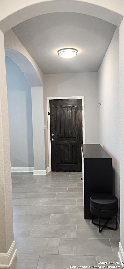 entrance foyer with arched walkways and baseboards