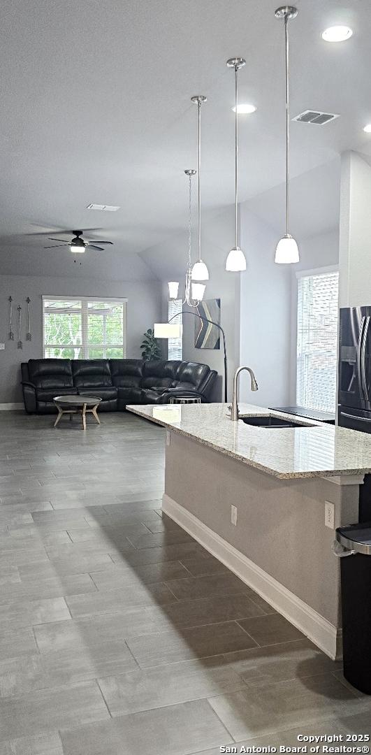 kitchen with a ceiling fan, visible vents, light stone counters, baseboards, and recessed lighting