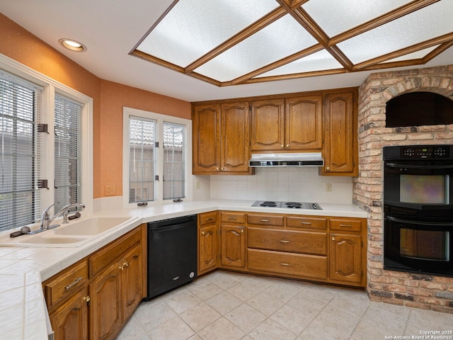 9 Chester Downs, San Antonio, TX 78257 - kitchen with a sink, brown cabinetry, black appliances, and under cabinet range hood