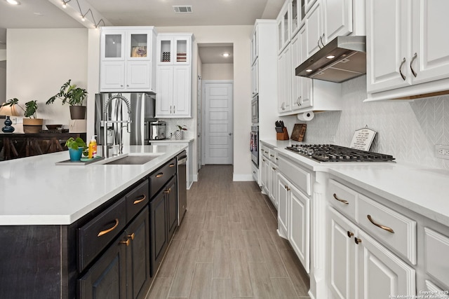 kitchen with visible vents, light countertops, under cabinet range hood, white cabinets, and stainless steel appliances