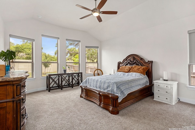 bedroom featuring light colored carpet, a ceiling fan, baseboards, and lofted ceiling