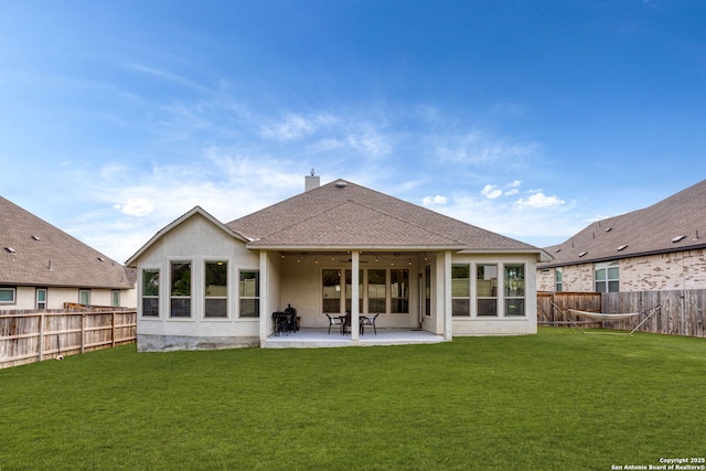 back of property featuring a yard, a ceiling fan, and a fenced backyard