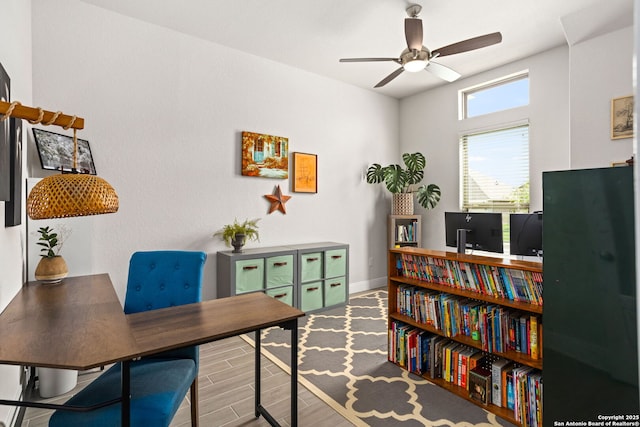 office area with baseboards, ceiling fan, and wood finished floors