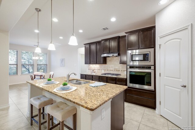 kitchen featuring backsplash, visible vents, appliances with stainless steel finishes, a sink, and light tile patterned floors