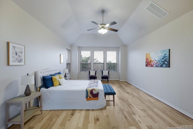 bedroom featuring visible vents, baseboards, lofted ceiling, and wood finished floors