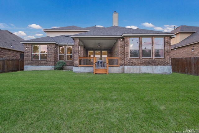 back of house featuring a lawn, a fenced backyard, and ceiling fan