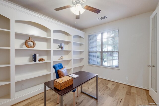 office space featuring baseboards, a ceiling fan, wood finished floors, and visible vents