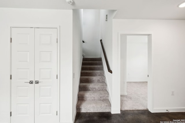 staircase featuring baseboards and carpet flooring