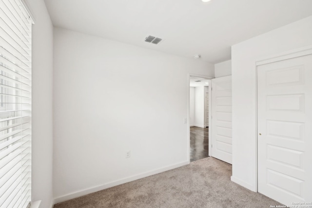 unfurnished bedroom with carpet floors, baseboards, visible vents, and a closet