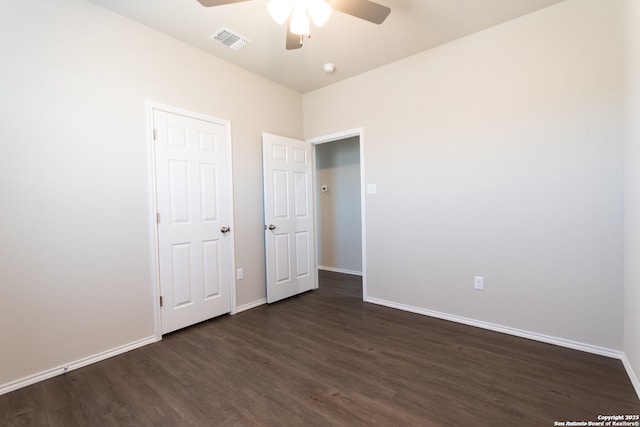 unfurnished bedroom with visible vents, dark wood finished floors, and baseboards