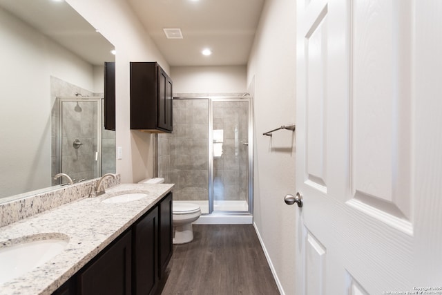 full bath featuring wood finished floors, toilet, a sink, and a stall shower