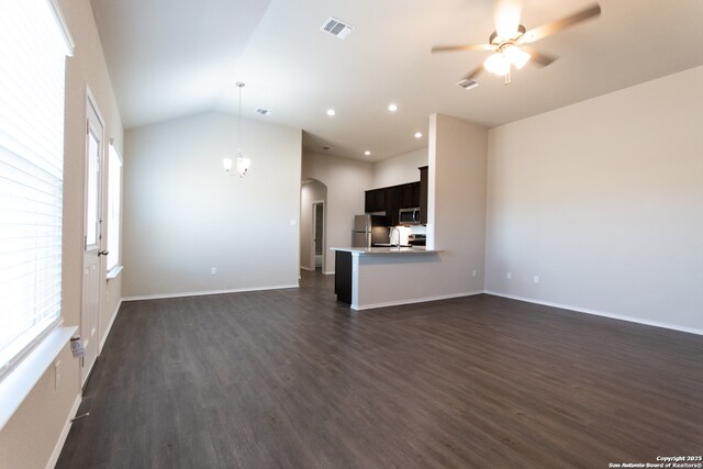 unfurnished living room featuring visible vents, dark wood-style flooring, arched walkways, a sink, and ceiling fan with notable chandelier
