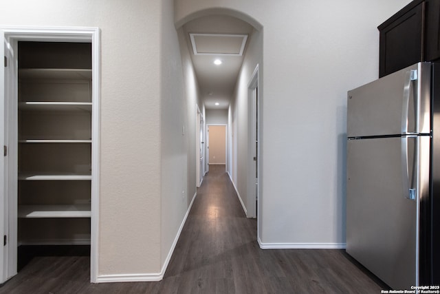 corridor with baseboards, attic access, and dark wood finished floors