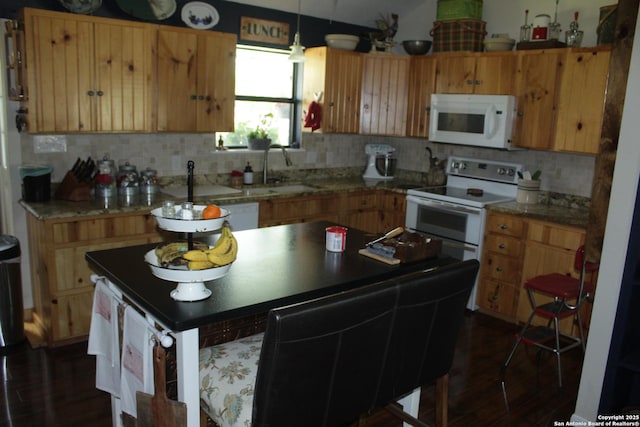kitchen featuring backsplash, hanging light fixtures, dark wood finished floors, a sink, and white appliances