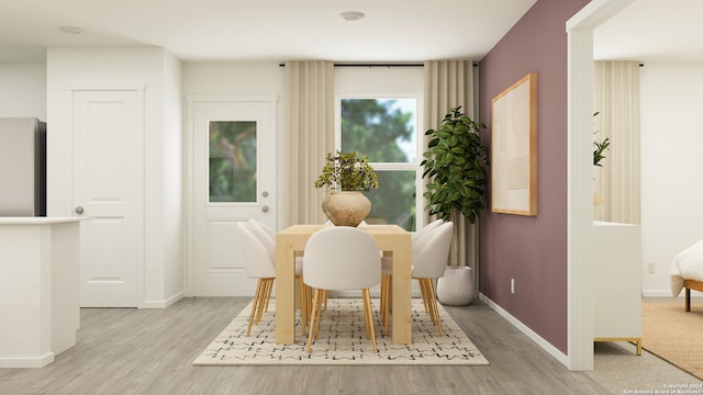 dining area featuring baseboards and light wood finished floors
