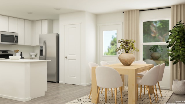 kitchen featuring white cabinets, appliances with stainless steel finishes, light countertops, baseboards, and light wood-type flooring