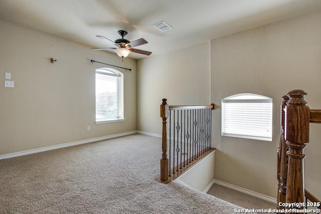 stairs with baseboards, ceiling fan, carpet, and visible vents