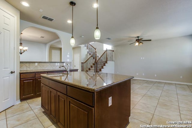 kitchen with ceiling fan, a sink, arched walkways, light tile patterned floors, and visible vents