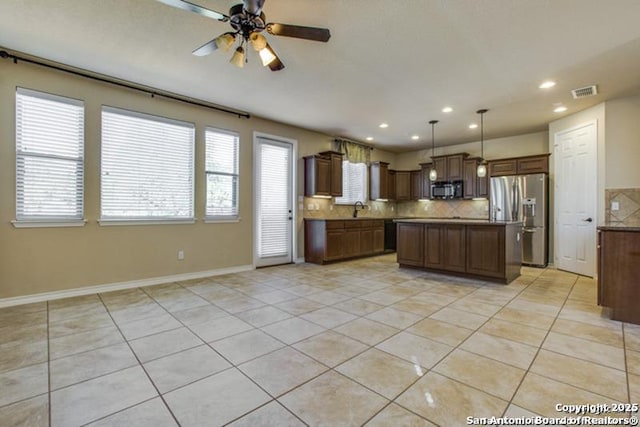 17739 Via Del Oro, San Antonio, TX 78257 - kitchen with visible vents, light tile patterned flooring, black microwave, stainless steel refrigerator with ice dispenser, and a ceiling fan
