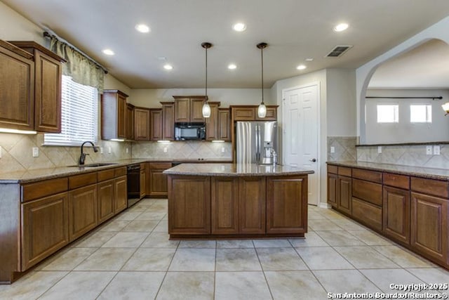 kitchen with visible vents, a kitchen island, a sink, backsplash, and black appliances