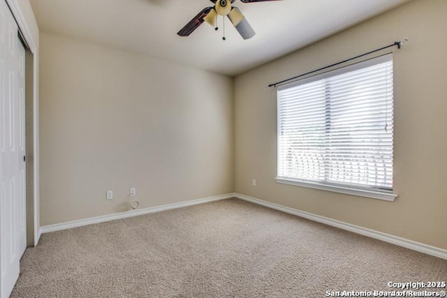unfurnished bedroom with baseboards, light colored carpet, ceiling fan, and a closet