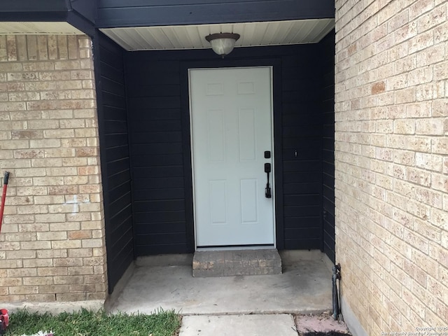 doorway to property with brick siding