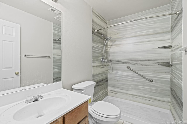 bathroom with vanity, toilet, a marble finish shower, and visible vents