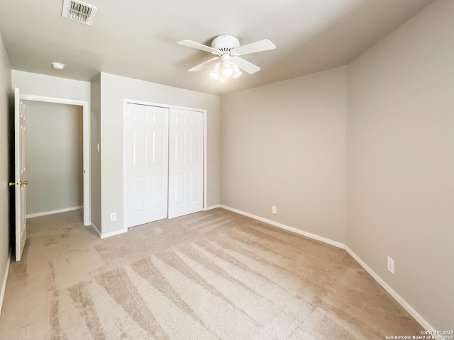 unfurnished bedroom with ceiling fan, visible vents, baseboards, a closet, and carpet