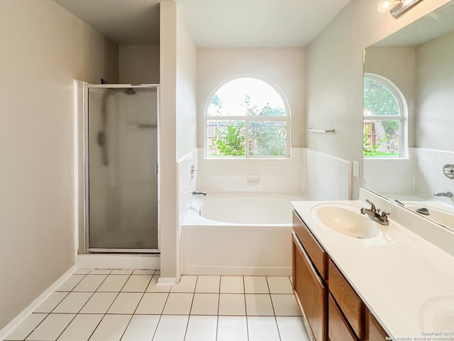 bathroom with double vanity, a bath, a shower stall, a sink, and tile patterned floors