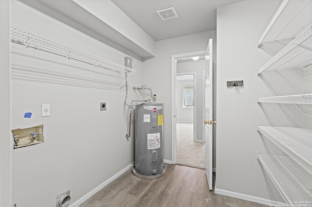 utilities with visible vents and electric water heater