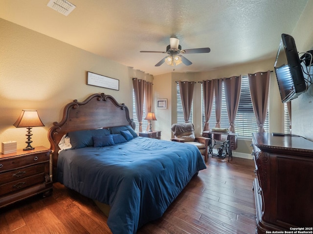 bedroom featuring dark wood-style flooring, ceiling fan, a textured ceiling, baseboards, and visible vents