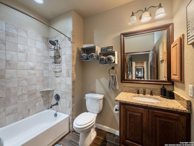 full bathroom featuring vanity, a textured wall, toilet, wood finish floors, and shower / bath combination