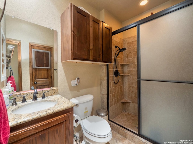bathroom with vanity, toilet, and a stall shower