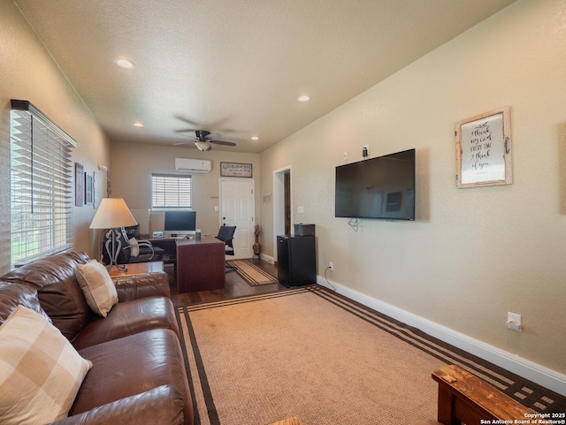 living area featuring recessed lighting, baseboards, ceiling fan, and a wall unit AC